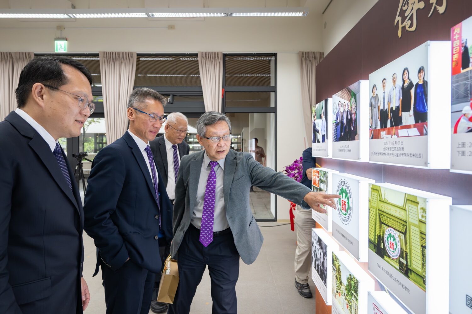 見證合校9年開啟新篇章 清華大學竹師教育學院大樓嶄新落成 | 索引新聞 INDEX News 清大高為元校長與貴賓們,觀賞竹師教育學院歷年照片牆。(圖/記者黃溎芬翻攝)