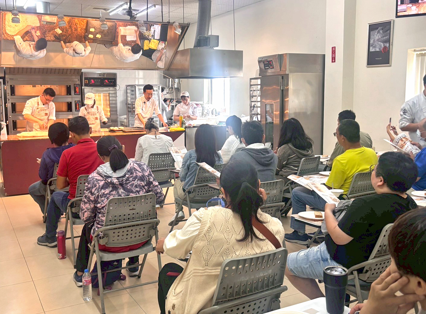 由聯華製粉烘焙顧問楊智偉老師(前方中間站立者)示範全粒粉應用,實作說明吸水、麵團與發酵等關鍵。圖/聯華製粉提供