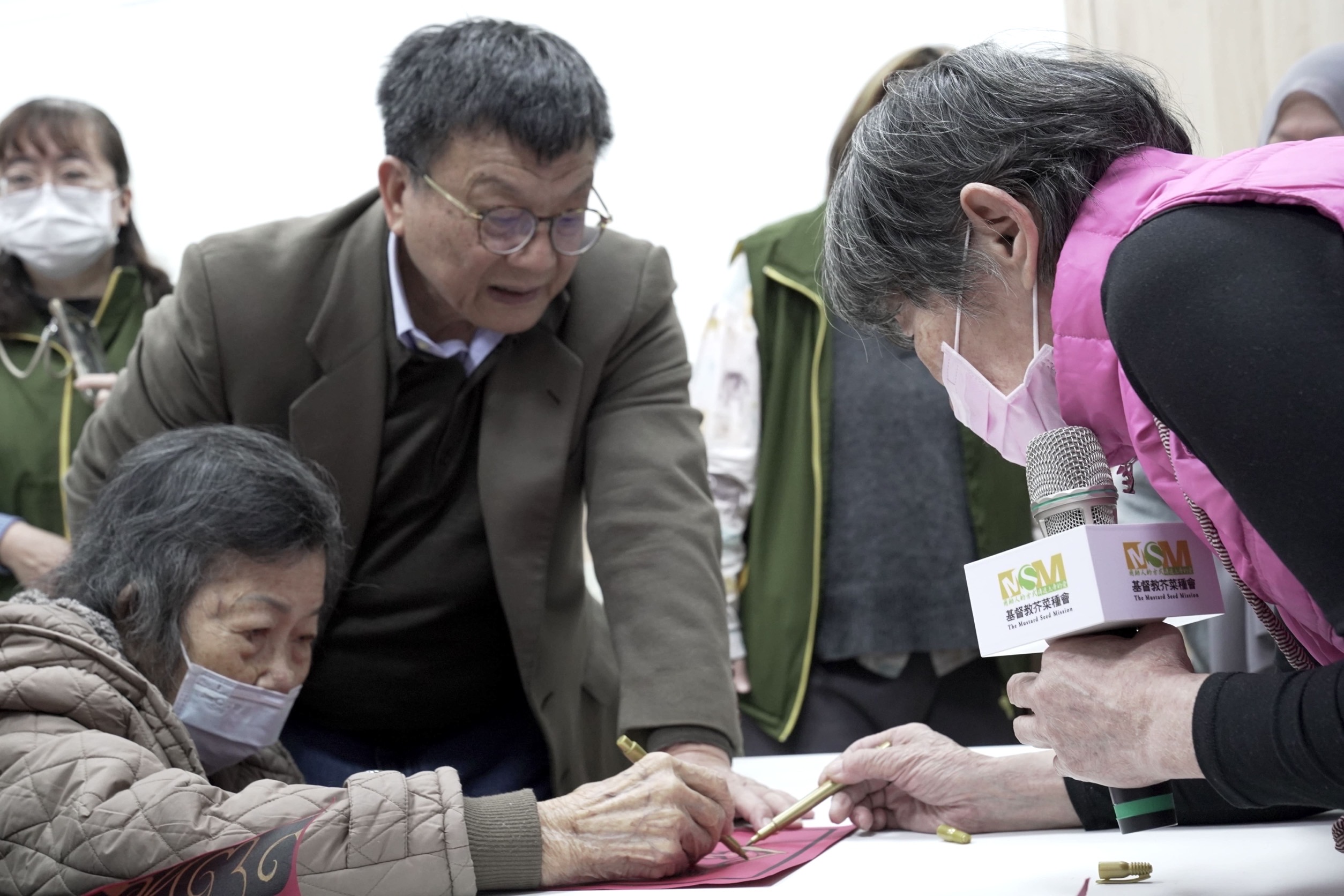 《圖說》芥菜種會「共學師」(右一)引導五股助人網「樂福學堂」長者描繪年畫迎新春。〈芥菜種會提供〉