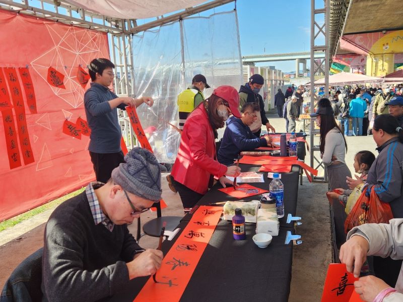 《圖說》重新觀光市集迎春書法大師現場書寫春聯，民眾能依喜好挑選春聯內容，將滿滿祝福帶回家。〈高灘處提供〉