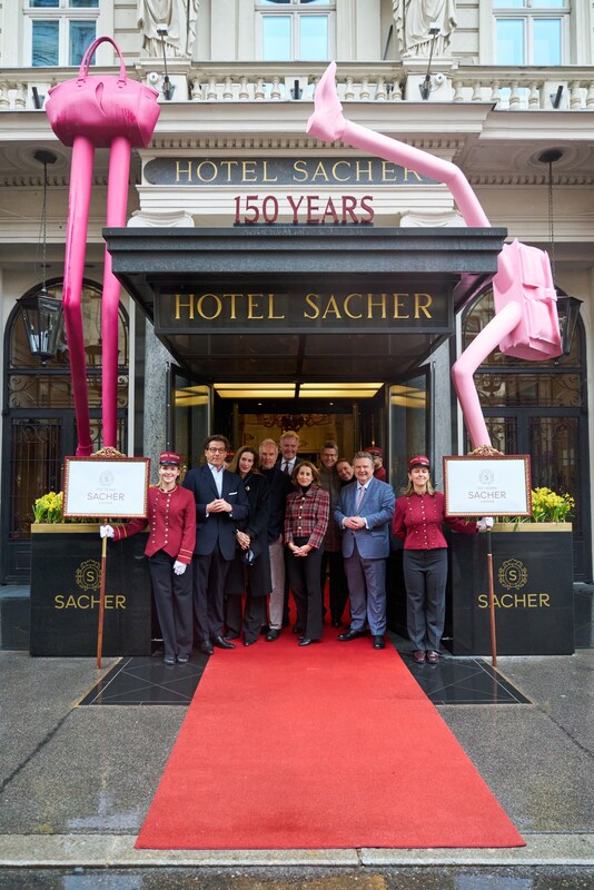 The owner families Gürtler and Winkler, artist Erwin Wurm with his two sculptures “Step Big” and “Dancer,” and the Mayor of Vienna, Dr. Michael Ludwig, at the unveiling marking the 150th anniversary of Hotel Sacher Vienna in front of the hotel entrance.
