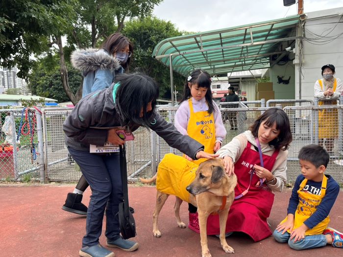 《圖說》志工協助親子與狗老師互動。〈動保處提供〉